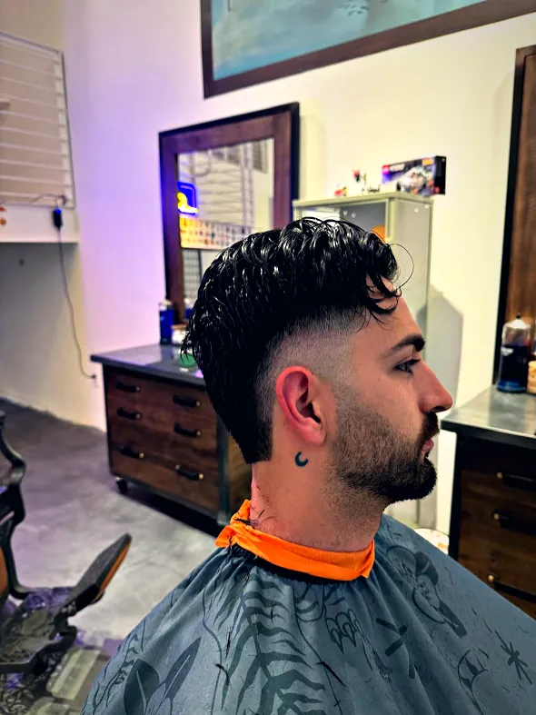 Textured top with a high fade and shaped beard